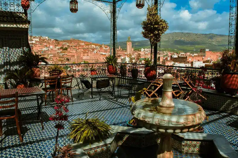 a patio with a fountain and a city in the background in Moroccan Ceremonies