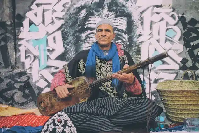 A Moroccan Maalem in Playing the Guenbri in the streets of Essaouira